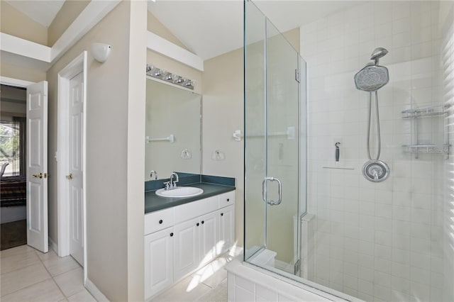 bathroom with vanity, a shower stall, tile patterned floors, and vaulted ceiling