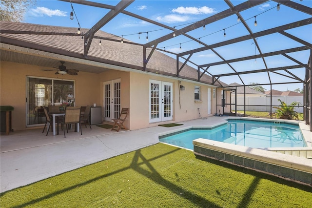 view of pool featuring a yard, glass enclosure, french doors, and a patio