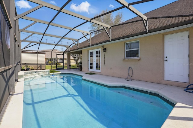 view of pool featuring a lanai, french doors, a pool with connected hot tub, and a patio