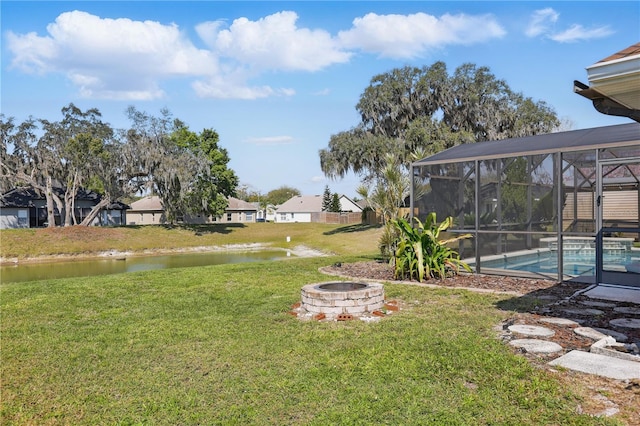 view of yard featuring a fire pit, a water view, a residential view, glass enclosure, and an outdoor pool