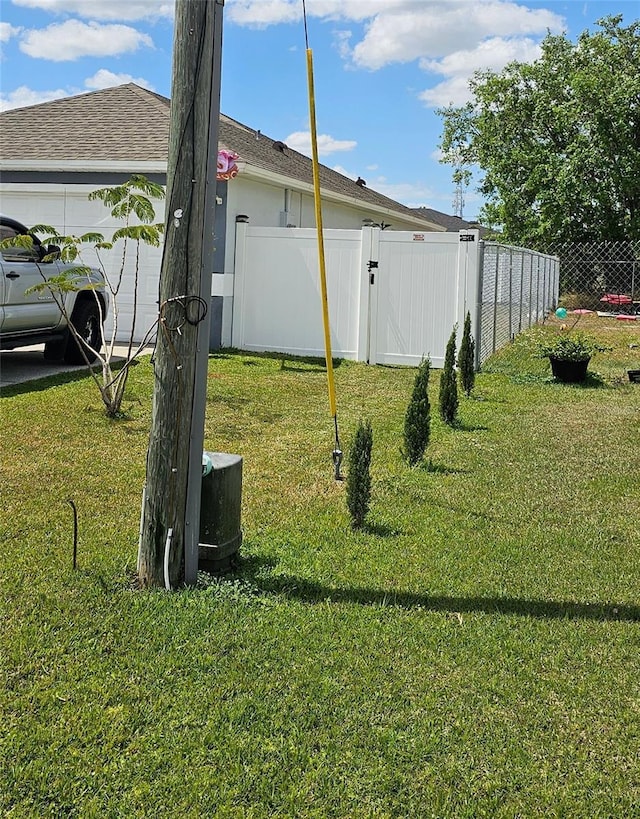 633 Kangaroo Dr, Kissimmee, FL 34759 - view of yard featuring fence, a gate, and an attached garage