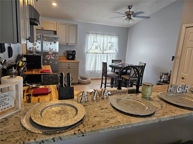 633 Kangaroo Dr, Kissimmee, FL 34759 - kitchen with freestanding refrigerator, a ceiling fan, light stone countertops, a textured ceiling, and light tile patterned floors