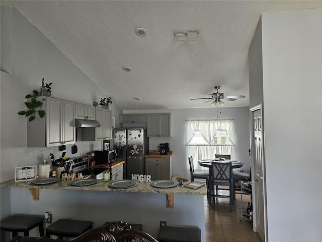 633 Kangaroo Dr, Kissimmee, FL 34759 - kitchen featuring tile patterned floors, gray cabinets, appliances with stainless steel finishes, a peninsula, and under cabinet range hood