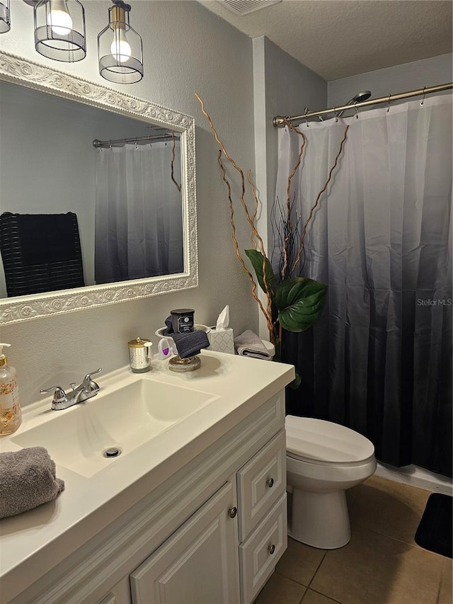 633 Kangaroo Dr, Kissimmee, FL 34759 - full bath with tile patterned floors, a shower with shower curtain, toilet, vanity, and a textured ceiling