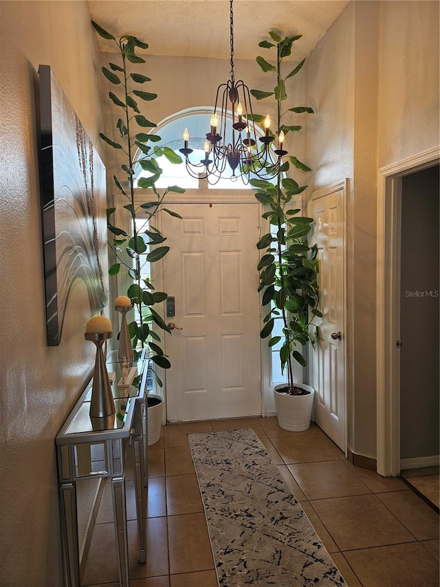 633 Kangaroo Dr, Kissimmee, FL 34759 - foyer entrance featuring a textured ceiling, a high ceiling, tile patterned flooring, and an inviting chandelier
