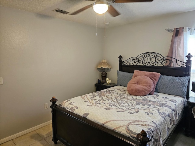 633 Kangaroo Dr, Kissimmee, FL 34759 - bedroom with light tile patterned floors, baseboards, a textured ceiling, visible vents, and a ceiling fan