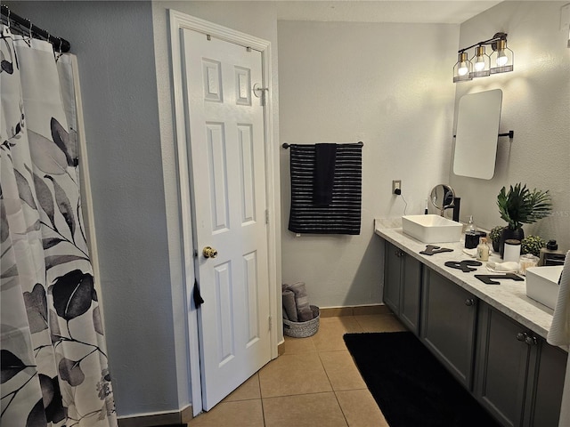 633 Kangaroo Dr, Kissimmee, FL 34759 - bathroom featuring double vanity, tile patterned flooring, a sink, and baseboards