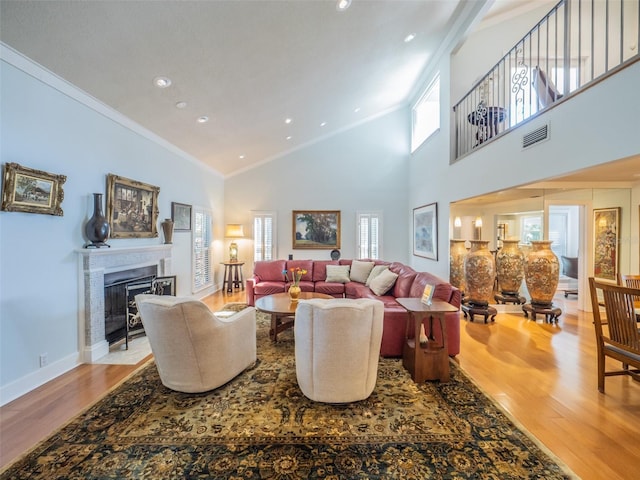 living area featuring crown molding, wood finished floors, and visible vents