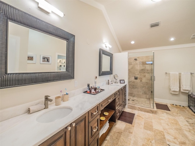 bathroom with visible vents, crown molding, double vanity, a stall shower, and a sink