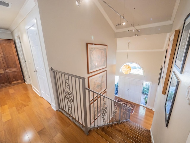 foyer entrance with wood finished floors, visible vents, and high vaulted ceiling