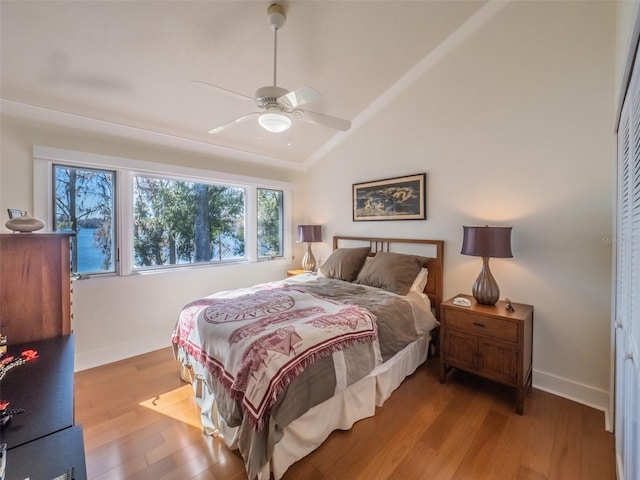 bedroom with ceiling fan, baseboards, lofted ceiling, and wood finished floors