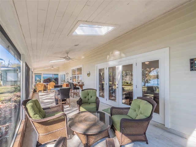 sunroom with wooden ceiling, a ceiling fan, and lofted ceiling with skylight