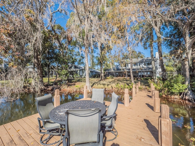 view of dock featuring a water view and outdoor dining space