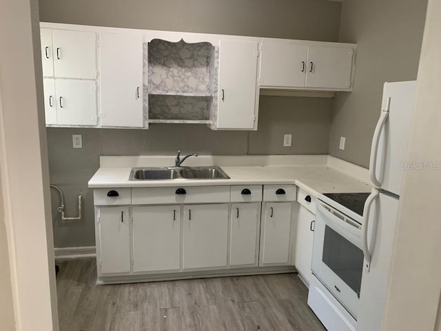 kitchen with white appliances, white cabinets, light wood-style flooring, and a sink