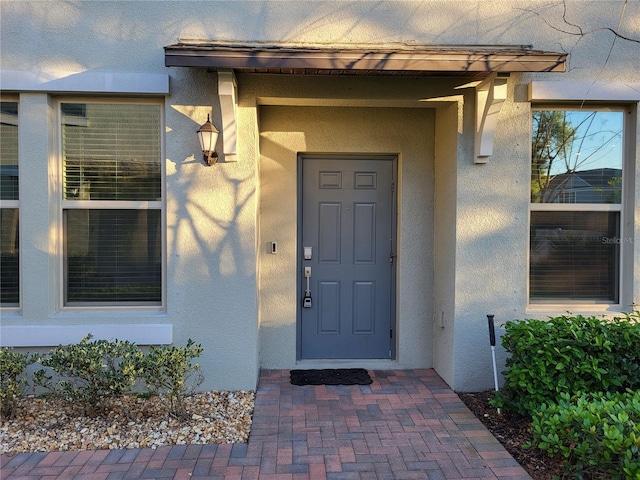 view of exterior entry featuring stucco siding