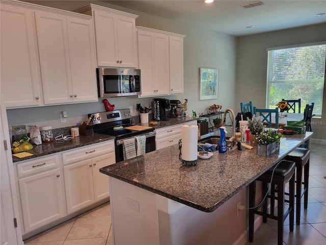 kitchen featuring white cabinetry, dark stone countertops, and appliances with stainless steel finishes