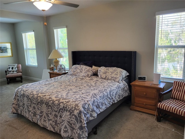 carpeted bedroom with multiple windows, baseboards, and ceiling fan