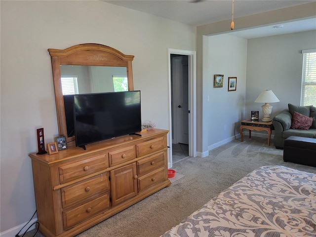 bedroom featuring light colored carpet and baseboards