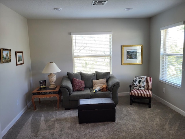 carpeted living room featuring visible vents and baseboards