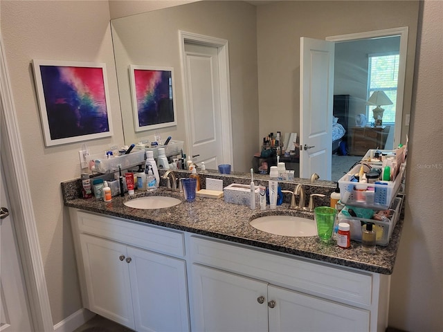 bathroom featuring a sink, ensuite bath, and double vanity