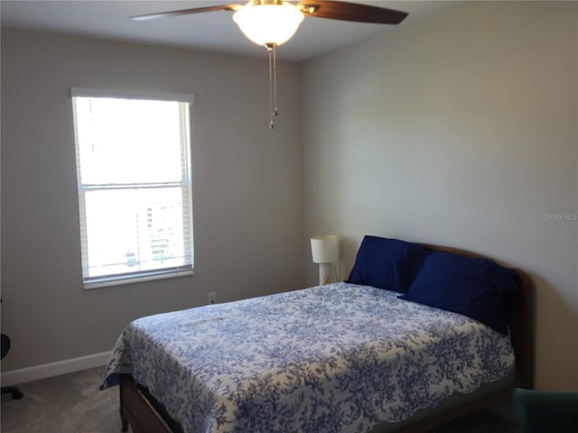 carpeted bedroom featuring baseboards and ceiling fan