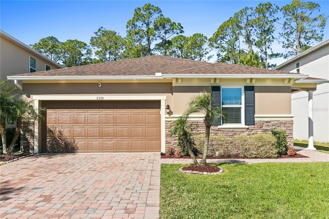 single story home featuring an attached garage, stucco siding, a front lawn, stone siding, and decorative driveway