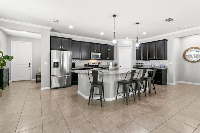 kitchen featuring a spacious island, visible vents, decorative backsplash, a kitchen breakfast bar, and stainless steel appliances