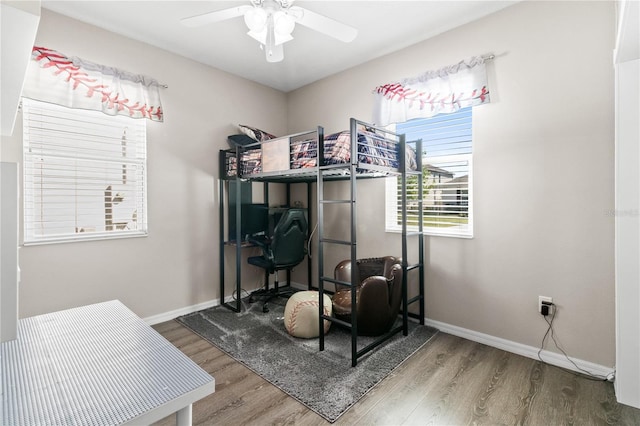 bedroom featuring wood finished floors, baseboards, and ceiling fan