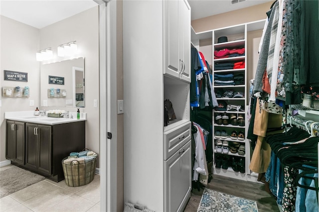 walk in closet with a sink, visible vents, and light tile patterned floors