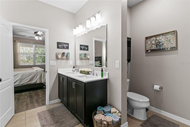 ensuite bathroom with a ceiling fan, ensuite bath, a sink, tile patterned flooring, and toilet