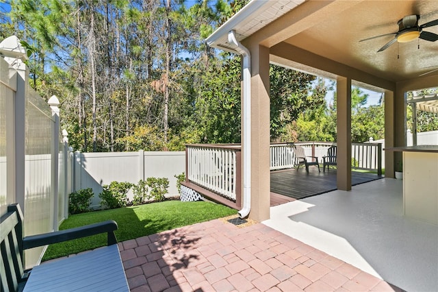 view of patio featuring a deck, fence private yard, and a ceiling fan