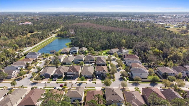 aerial view featuring a residential view, a wooded view, and a water view