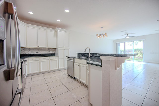 kitchen featuring light tile patterned floors, backsplash, appliances with stainless steel finishes, and a sink