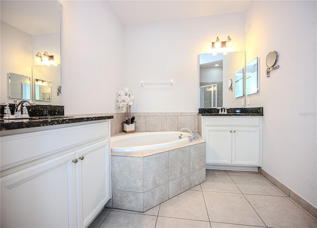 bathroom featuring tile patterned floors, two vanities, a stall shower, a sink, and a bath