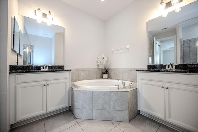 bathroom featuring tile patterned floors, a bath, a shower stall, and a sink