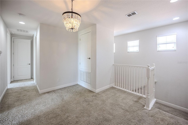 empty room with visible vents, baseboards, and carpet