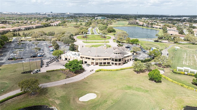 drone / aerial view with view of golf course and a water view