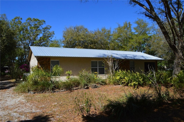 view of front of home featuring metal roof and stucco siding