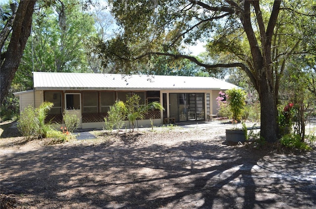 view of front of house featuring metal roof and a sunroom