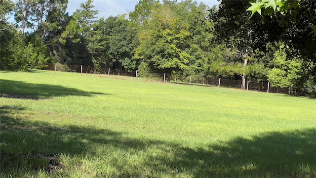 view of yard with a rural view and fence