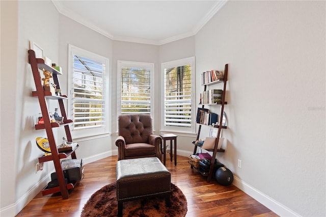 sitting room with baseboards, wood finished floors, and ornamental molding