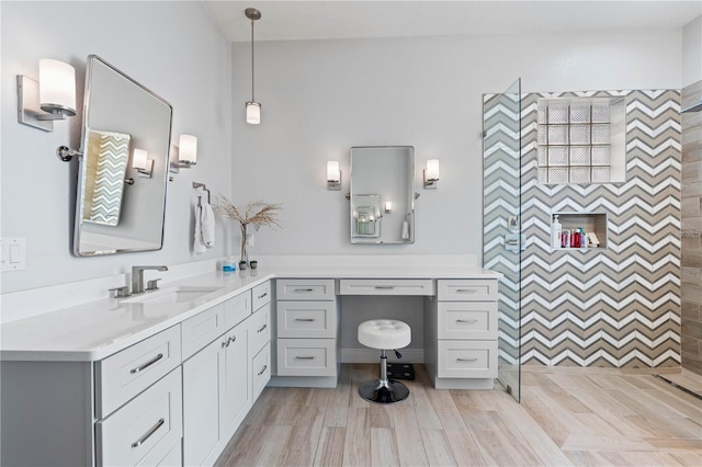 bathroom featuring vanity, walk in shower, and wood finished floors