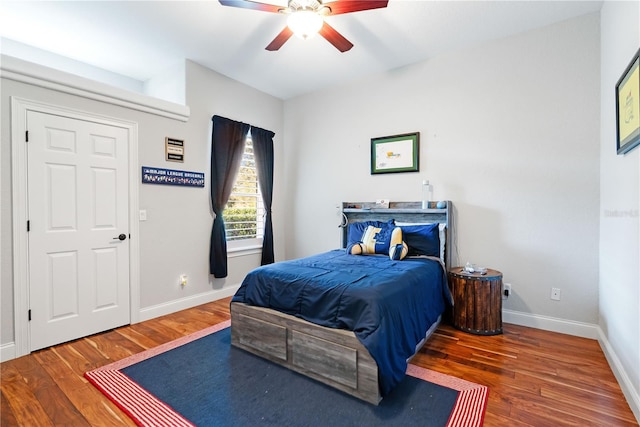 bedroom featuring a ceiling fan, baseboards, and wood finished floors