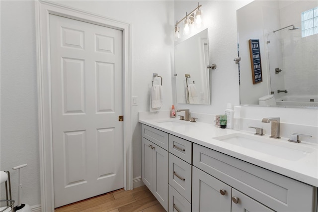 full bath featuring bathtub / shower combination, double vanity, wood finished floors, and a sink