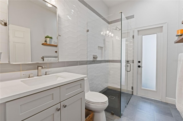 bathroom featuring vanity, toilet, and a shower stall