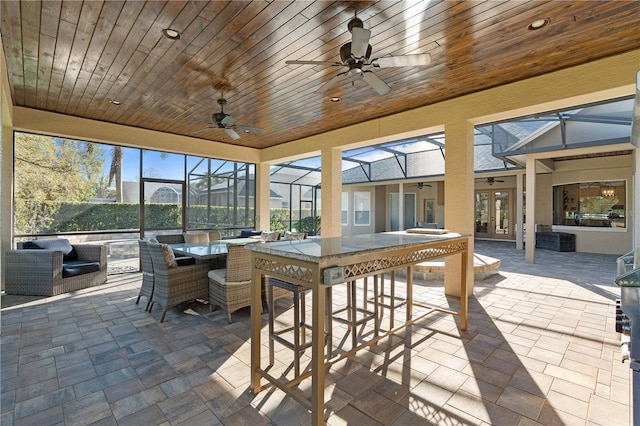 sunroom featuring wood ceiling and ceiling fan