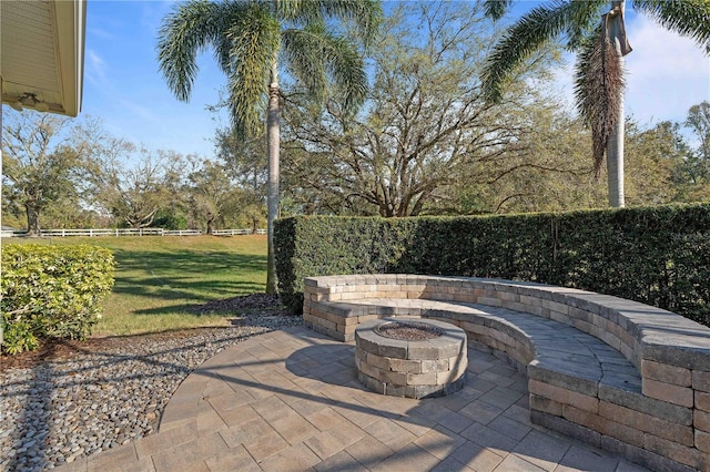 view of patio / terrace with a fire pit and fence