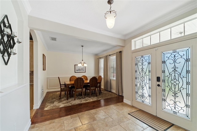 foyer entrance featuring visible vents, stone tile floors, crown molding, and french doors