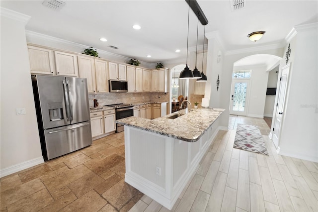 kitchen with a sink, visible vents, arched walkways, and stainless steel appliances