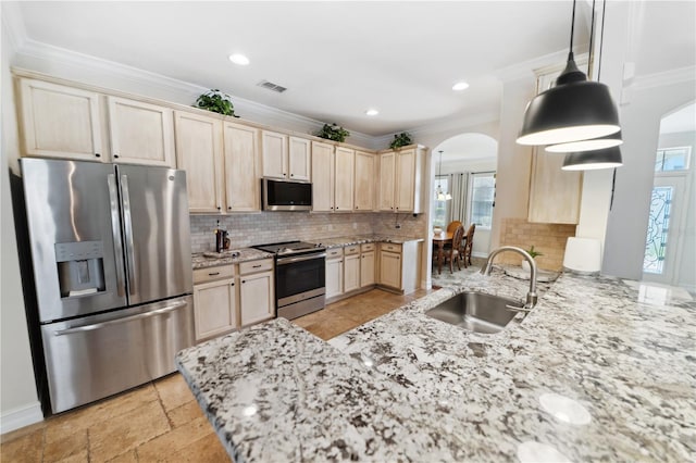 kitchen with light brown cabinets, arched walkways, a sink, appliances with stainless steel finishes, and crown molding